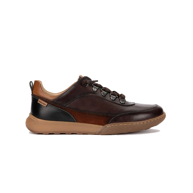 Perfil lateral del zapato casual de mujer Pikolinos Viana en color caoba. Zapatilla de piel marrón con suela de goma caramelo y pespuntes blancos.